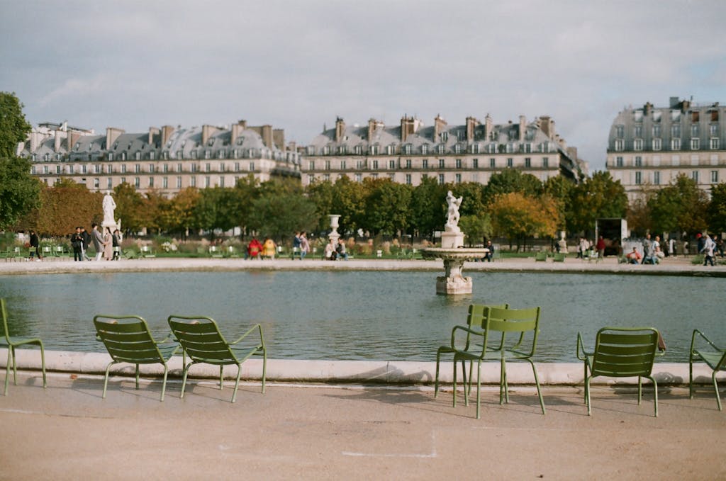 Charming scene of the Tuileries Garden with iconic Parisian architecture and a peaceful fountain view.