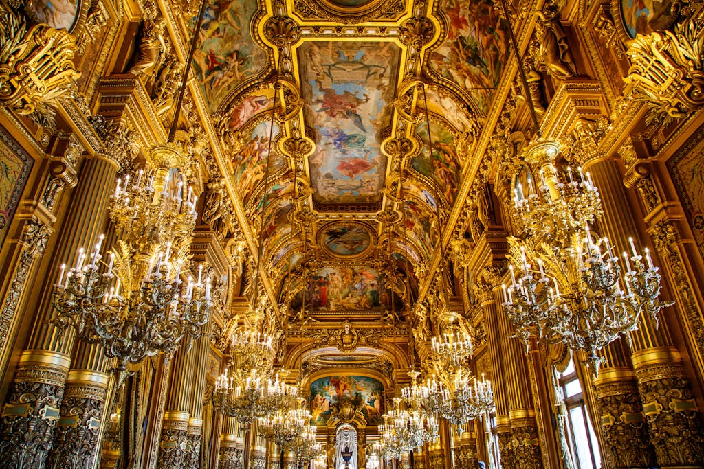 Opulent golden hallway with grand chandeliers and intricate ceiling artwork in a classic Parisian palace.