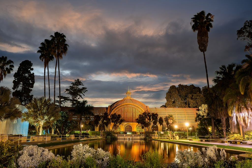 Dramatic sunset over the historic Botanical Building and reflecting pond in Balboa Park, San Diego.