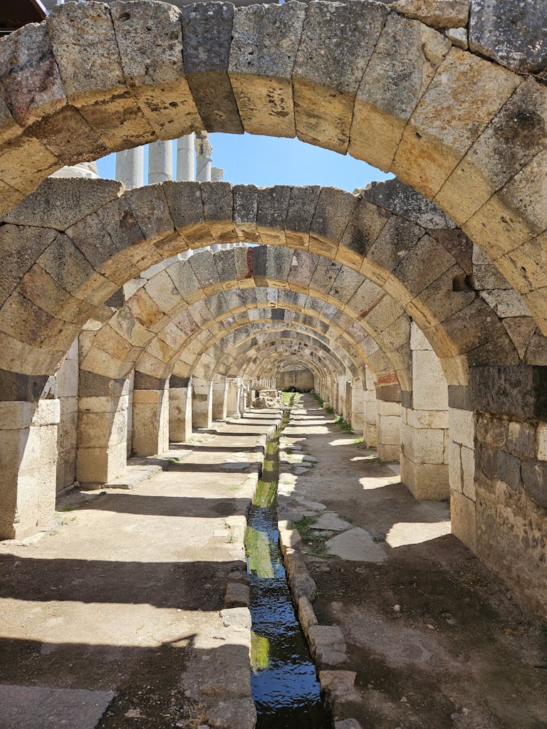 Intricate stone arches in İzmir's ancient Agora, showcasing Roman architecture's elegance.